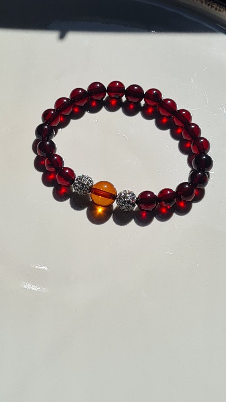 Красный браслет с янтарным шариком